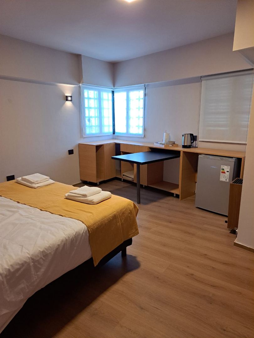 Dormitorio con frigobar y escritorio