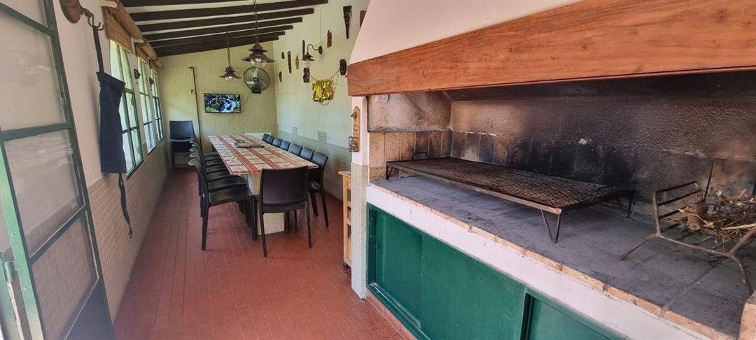 Quincho con parrilla grande y mesa larga